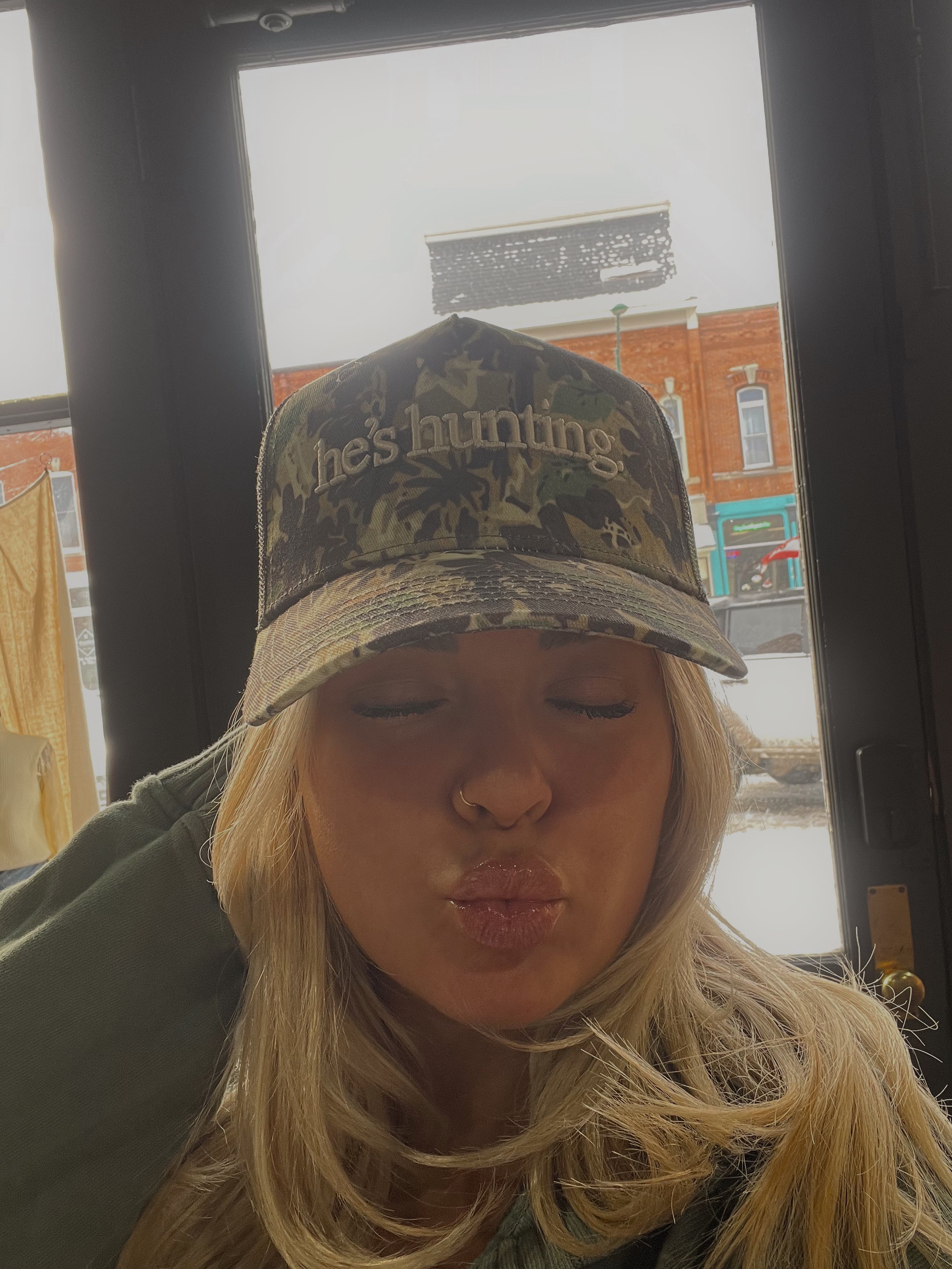HE’S HUNTING TRUCKER HAT